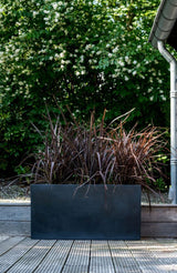 Jort Pflanzkübel Schwarz aus Fiberstone – runder Kübel im Lifestyle-Setting